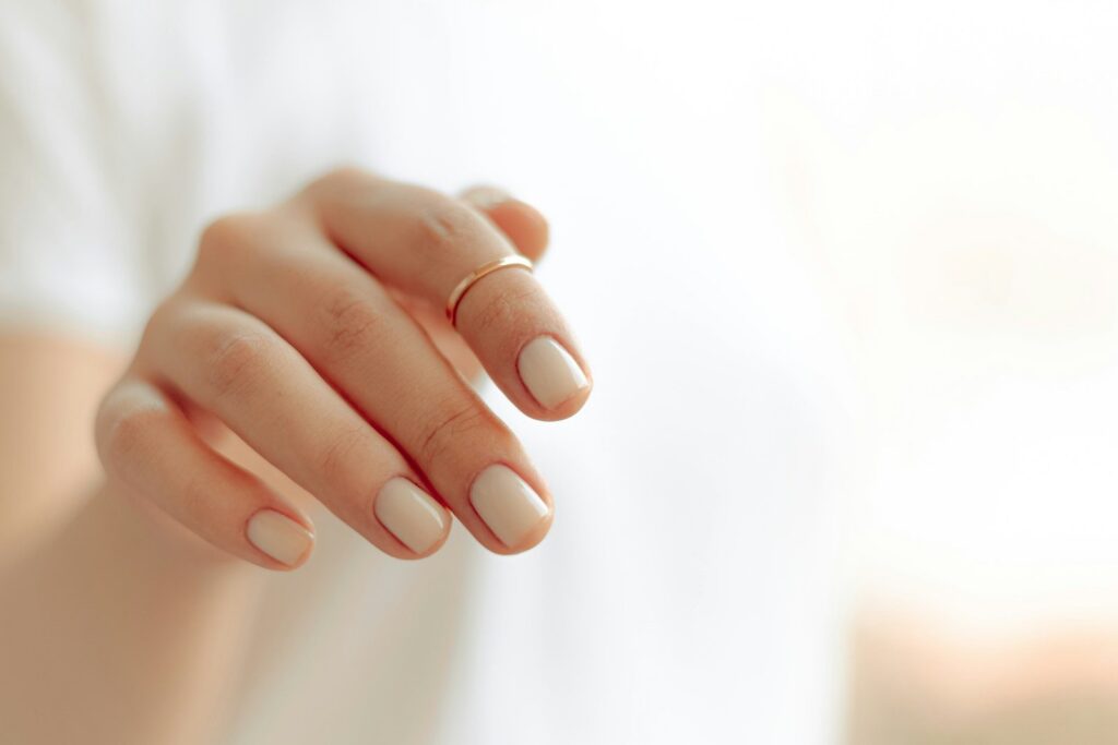 Main aux ongles soignés vernis de blanc